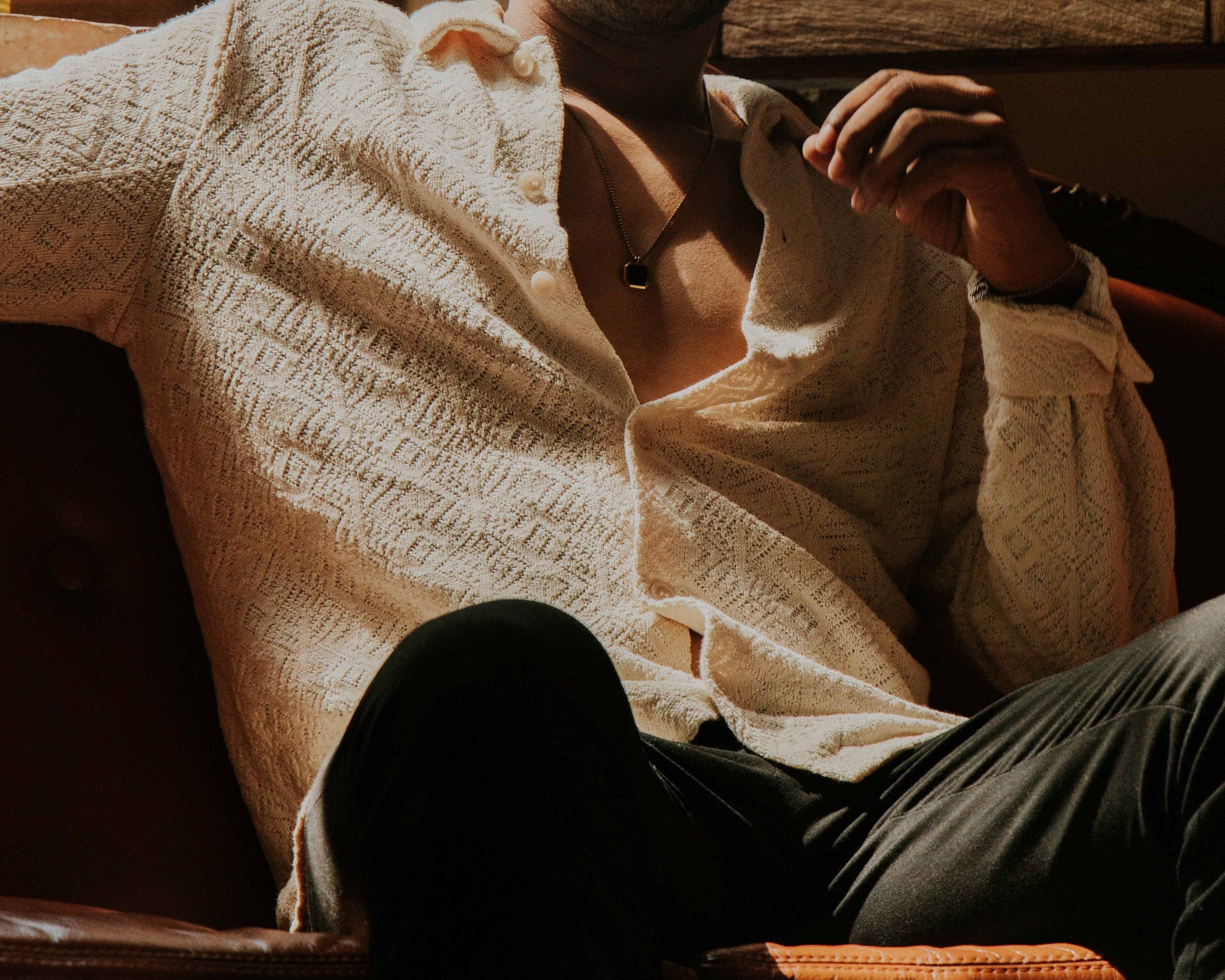 Person wrapped in a beige shirt, sitting on a couch with a warm glow.